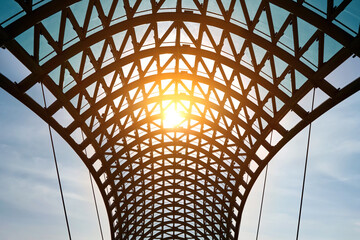 Wall Mural - Close-up of a metal arch with a glass roof against a beautiful blue sky.