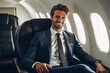 © Bargais - Smiling businessman in suit sitting in an airplane.