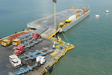 Empty lorries and trucks parked on a loading pier next floating pontoon as a part of container terminal in Puerto Barrios and wating for cargo operation.