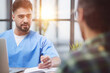 © Katsiaryna - Nurse explaining to a young male patient in an office in a hospital
