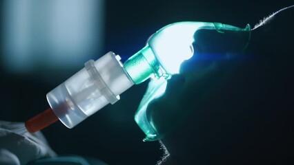 a female patient in medical mask is breathing oxygen support in a hospital next to heart rate machin