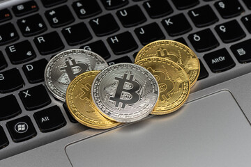 Wall Mural - Golden and silver bitcoin isolated on keyboard.