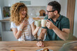 © Miljan Živković - Young couple man and woman enjoy cup of tea or coffee in the morning