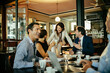 © Marko Geber - Group of business people having a meeting in a cafe bar