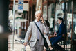 © Marko Geber - Mature businessman talking on his smart phone while commuting to work with his bicycle