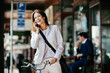 © Marko Geber - Mature caucasian businesswoman talking on a smart phone while commuting to work with a bicycle