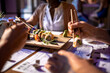 © Marko Geber - Diverse and mixed group of people having a meeting at a japanese styled sushi restaurant