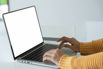 young woman working on laptop with blank screen with copy space screen for your advertising text message in office