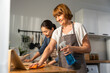© Kawee - Caucasian senior elderly woman cleaning kitchen in house with daughter.