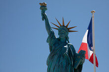 Statue Of Liberty With France Flag French Flutters Wave Over A Blue Sky Waving On Mat