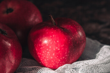 Close-up of a red fresh ripe red apple on a white napkin.