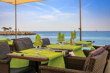 Wall Mural - Seaside promenade with outdoor restaurant tables along the Mediterranean Sea in the Old Town of Menton on the French Riviera, South of France