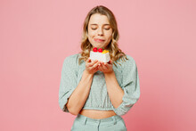 Young Smiling Satisfied Fun Happy Woman She Wear Casual Clothes Look At Tasty Piece Of Seet Cake Dessert, Lick Lips Isolated On Plain Pastel Light Pink Background Studio Portrait. Lifestyle Concept.