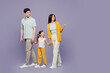© ViDi Studio - Full body happy young parents mom dad child kid daughter girl 6 years old wearing blue yellow casual clothes hold hands walk go point back aside isolated on plain purple background Family day concept