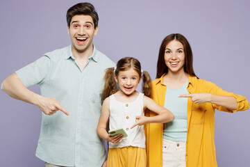 Wall Mural - Young parents mom dad with child kid daughter girl 6 years old wear blue yellow casual clothes hold use point finger mobile cell phone chatting isolated on plain purple background. Family day concept.