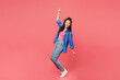 © ViDi Studio - Full body side profile view young woman of African American ethnicity wear blue shirt casual clothes stand on toes with outstretched hands leaning back isolated on plain pastel pink background studio.