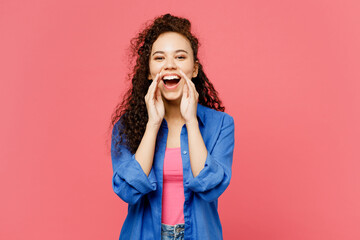 Wall Mural - Young promoter woman of African American ethnicity wear blue shirt casual clothes scream sharing hot news about sales discount with hands near mouth isolated on plain pastel pink background studio.