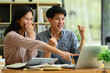 © Prathankarnpap - Overjoyed college students looking at laptop screen celebrating success, exam results together
