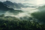 Fototapeta Las - The mountains are covered in a layer of mist and clouds Generative AI