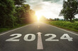 © MangKangMangMee - New year 2024 or straightforward concept. Text 2024 written on the road in the middle of asphalt road at sunset.Concept of planning and challenge, business strategy, opportunity ,hope, new life change
