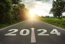 New Year 2024 Or Straightforward Concept. Text 2024 Written On The Road In The Middle Of Asphalt Road At Sunset.Concept Of Planning And Challenge, Business Strategy, Opportunity ,hope, New Life Change