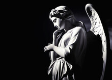 White Stone Angel Statue Isolated On Black Background With Copy Space