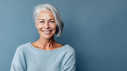 Poster - Woman 50-60 in blue sweater, blue background, copy space