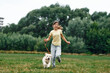 © standret - Cute little girl is with golden retriever dog on the field