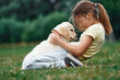 © standret - On the ground. Cute little girl is with golden retriever dog on the field