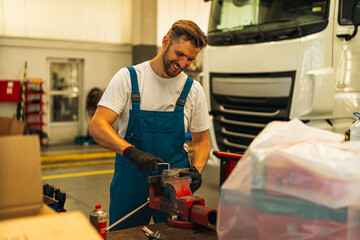 Portrait Shot of a Handsome Mechanic Working on a truck workshop Service. Professional Repairman. Modern Clean Workshop.