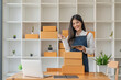 © Natee Meepian - Startup SME small business entrepreneur of freelance Asian woman using laptop and box to receive orders online to prepare to pack sell to customers, online sme business ideas