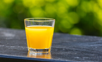 Wall Mural - Orange juice in a glass in nature