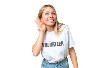 Wall Mural - Young volunteer woman over isolated chroma key background listening to something by putting hand on the ear