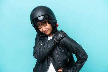 Wall Mural - Young Argentinian woman with a motorcycle helmet isolated on blue background suffering from pain in shoulder for having made an effort