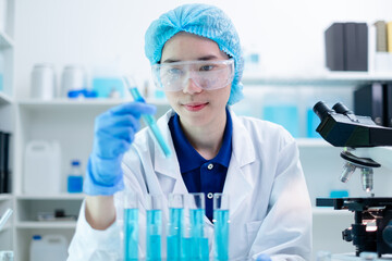 Wall Mural - Female scientist hold test tube with a blue liquid deep in research and analysis. Expertise chemistry, biology, and biotechnology, scientific precision, medical substances, pharmaceutical solutions.