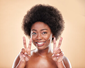 Wall Mural - Portrait, beauty or peace sign for skincare with a black woman in studio on beige background. Face, smile and hand gesture with a happy young afro model posing for natural cosmetics or transformation