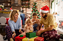 Young Caucasian Family Opening Presents During Christmas And The New Year Holidays In The Living Room In The Morning
