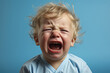 crying baby little boy on blue background