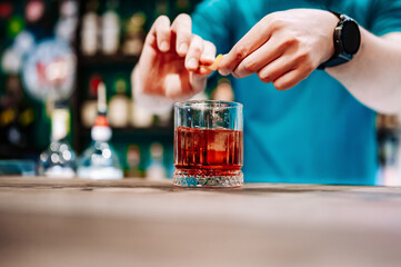 Wall Mural - man bartender hand making negroni cocktail in bar