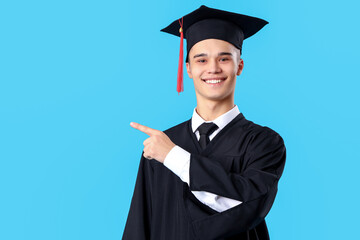 Canvas Print - Male graduate student pointing at something on blue background