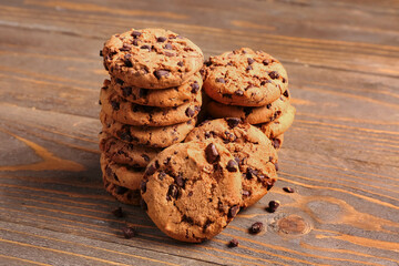 Tasty cookies with chocolate chips on wooden background