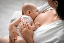 Young Woman Breastfeeding Her Baby At Home, Closeup