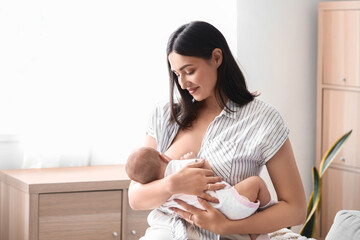 Wall Mural - Young woman breastfeeding her baby at home