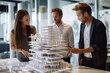 © Anne Schaum - Architects discussing over model of house in meeting room at office