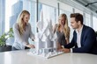 © Anne Schaum - Business people discussing over model of city in meeting at table in office