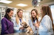 © Anne Schaum - Portrait of happy female veterinary team examining a dog in veterinary clinic