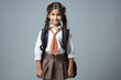 © StockImageFactory - Cute little Indian schoolgirl in uniform looking at camera with backpack while standing