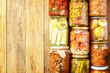 Healthy homemade fermented food. Various types of canned vegetables in glass jars on a rustic table. Home economics, autumn harvest preservation. View from above. Copy space.
