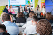 © Anton Gvozdikov - Unrecognizable businesspeople in formal clothes sitting on chairs and listening to speakers during seminar in modern conference center