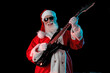 © TSViPhoto - Santa Claus playing the electric guitar in a nightclub at a Christmas and New Year party or Corporate events. Senior guitar player as Santa at a rock concert, festival, or celebration